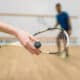 Young couple with rackets play squash game in indoor training club. Active sport lifestyle. Recreation workout, match with racquet