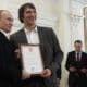epa03241075 Russian President Vladimir Putin (L) and Russian national ice hockey team member Alexander Ovechkin (2- L) hold a certificate thanking Ovechkin for the great contribution into the team's victory at the Novo-Ogaryovo residence outside Moscow, Russia, 29 May, 2012. Russia beat Slovakia in the the 2012 IIHF men's World Championship final in Helsinki on 20 May, 2012  EPA/SERGEI KARPUKHIN/POOL
