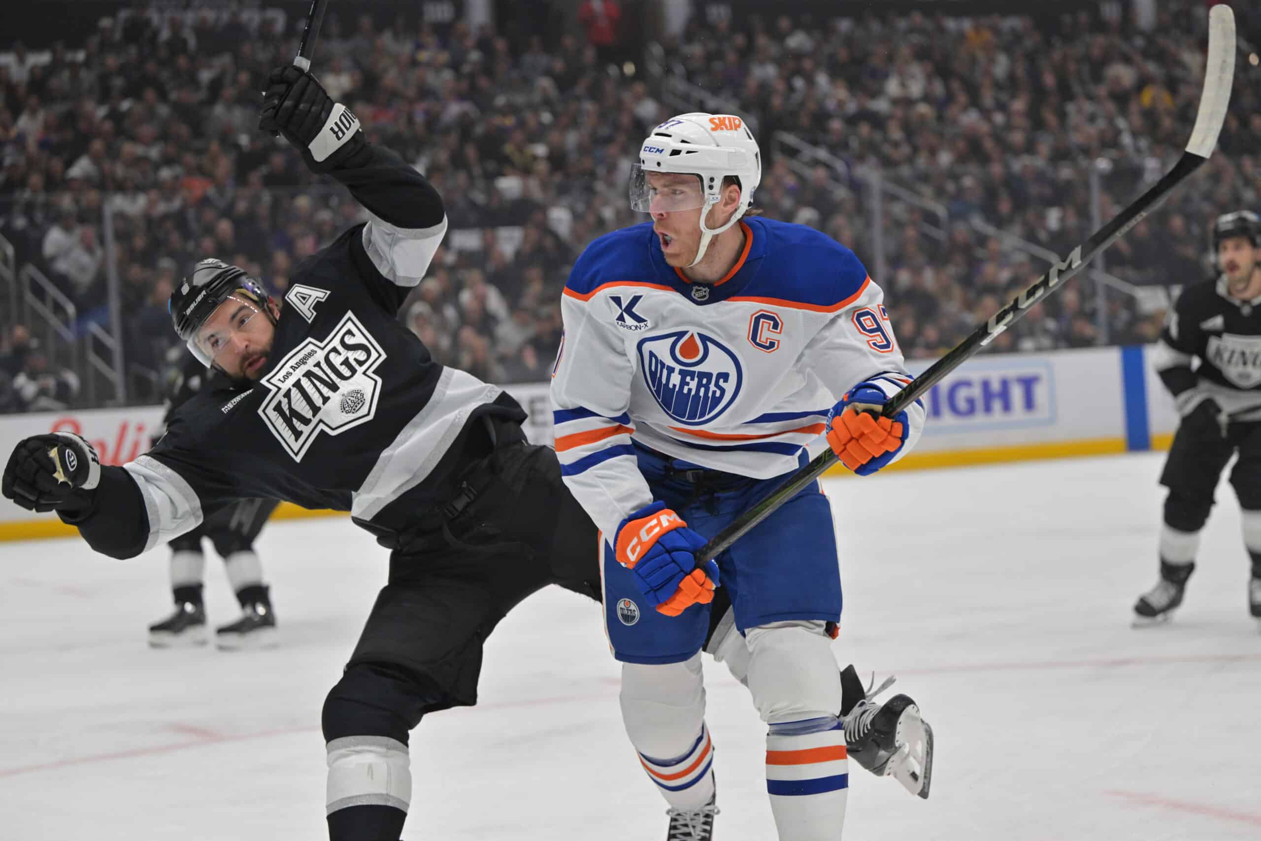 Apr 23, 2025; Los Angeles, California, USA; Los Angeles Kings defenseman Drew Doughty (8) and Edmonton Oilers center Connor McDavid (97) battle on the ice in the first period of game 2 of the 2025 Stanley Cup Playoffs at Crypto.com Arena. Mandatory Credit: Jayne Kamin-Oncea-Imagn Images