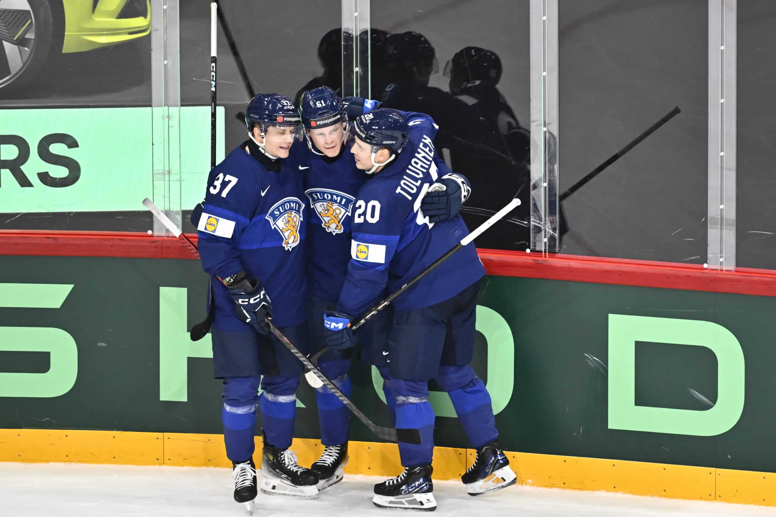 Atro Leppänen pelasi maajoukkueessa Leijonat-paidassa Sveitsin turnauksessa. Kuvassa mies valmistautuu otteluun alkulämmittelyssä ja nojailee kaukalon laitaa vasten.