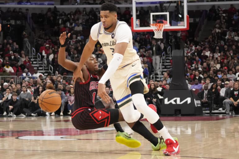 Dec 27, 2025; Chicago, Illinois, USA; Chicago Bulls guard Ayo Dosunmu (11) defends Milwaukee Bucks forward Giannis Antetokounmpo (34) during the second half at United Center. Mandatory Credit: David Banks-Imagn Images